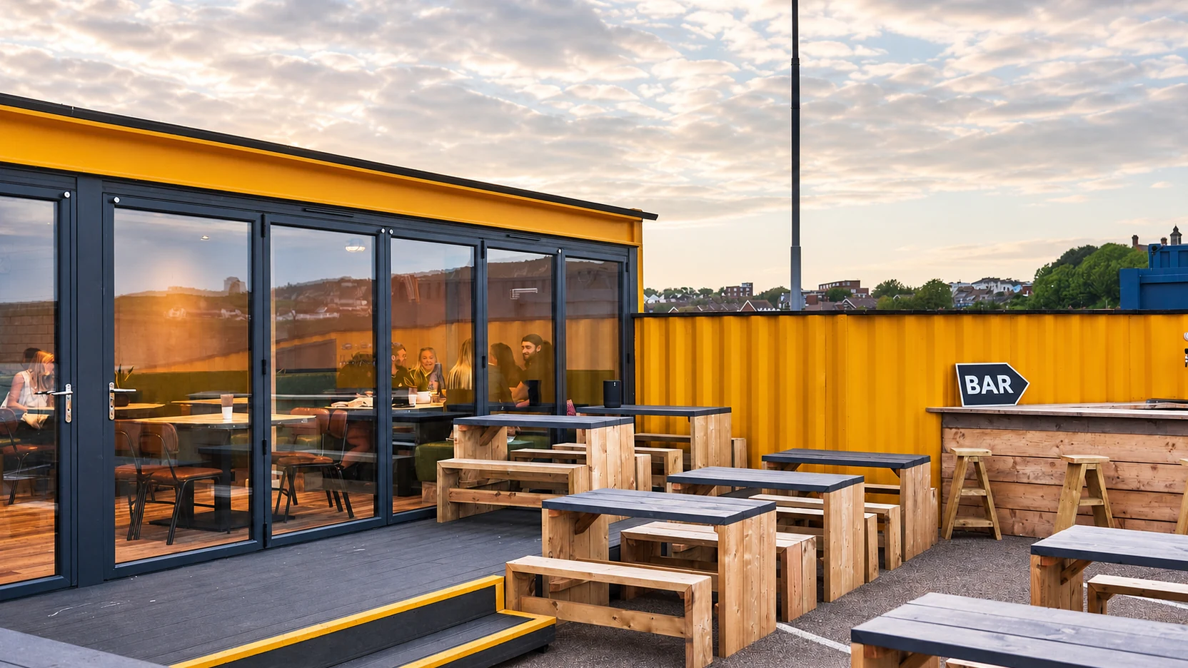 The yellow Sailbox container restaurant and outdoor seating at Folkestone Harbour